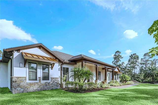 view of front facade with stucco siding, stone siding, and a front lawn