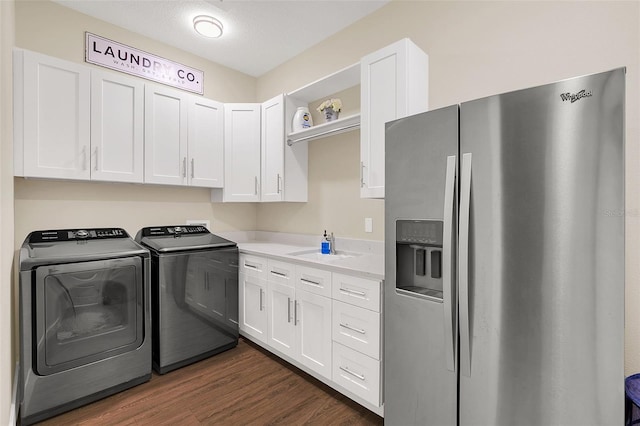 washroom with sink, cabinets, dark hardwood / wood-style flooring, a textured ceiling, and washer and clothes dryer