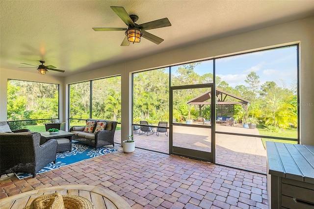 unfurnished sunroom with ceiling fan