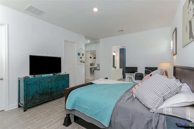 bedroom with connected bathroom and a textured ceiling