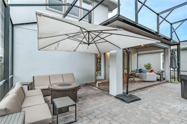 view of patio featuring a lanai and an outdoor living space with a fire pit