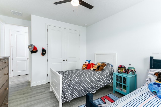 bedroom featuring ceiling fan, light wood-type flooring, and a closet