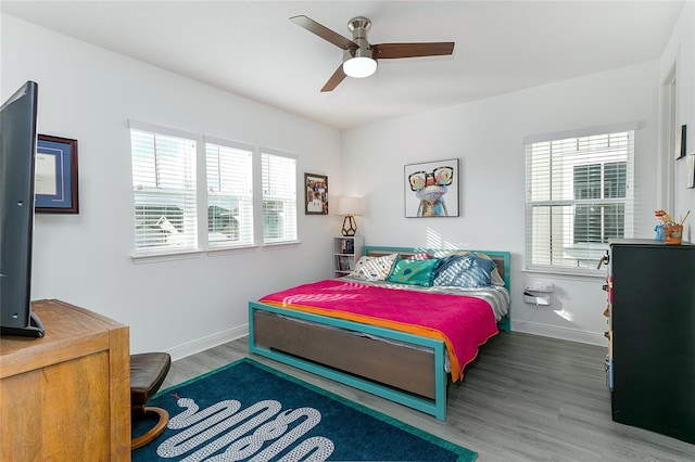 bedroom featuring multiple windows, ceiling fan, and hardwood / wood-style flooring