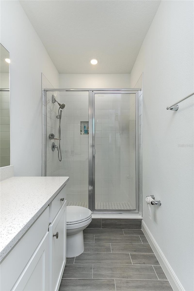 bathroom featuring walk in shower, vanity, and toilet