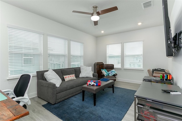 living room with ceiling fan and light hardwood / wood-style flooring