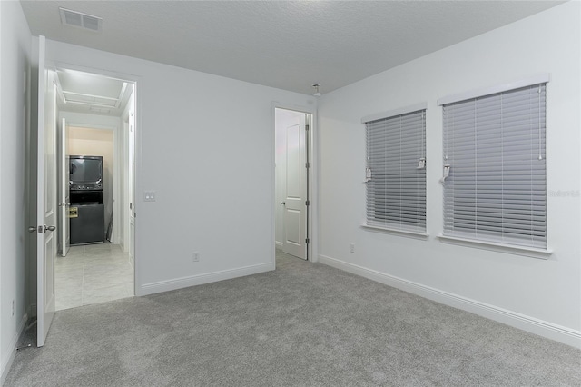 unfurnished bedroom with a textured ceiling and light colored carpet