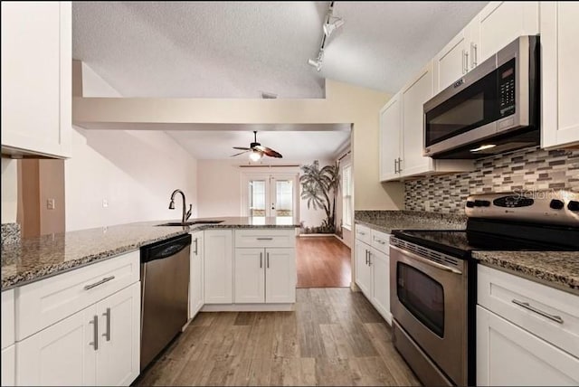 kitchen with stainless steel appliances, white cabinetry, and kitchen peninsula