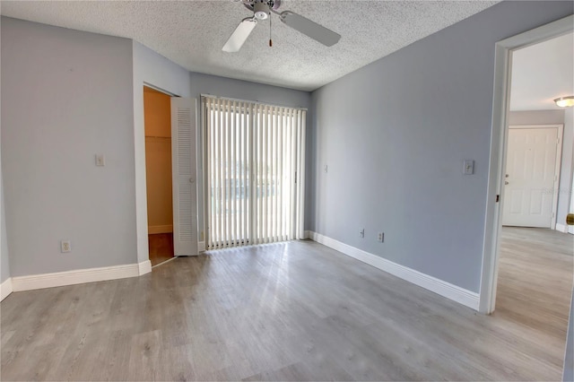 spare room with ceiling fan, a textured ceiling, and light wood-type flooring