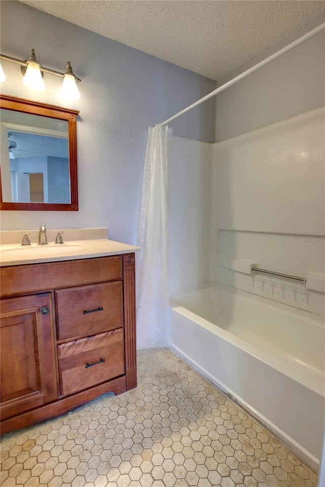 bathroom featuring vanity, shower / bath combo with shower curtain, and a textured ceiling