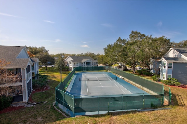 view of tennis court with a lawn