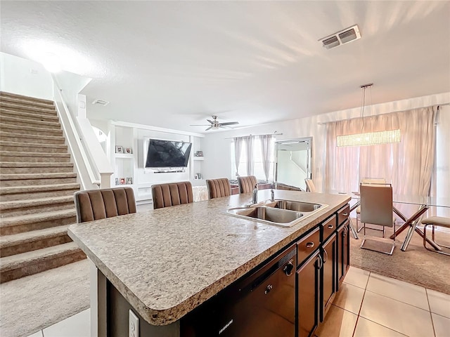 kitchen with sink, dark brown cabinets, dishwasher, an island with sink, and ceiling fan