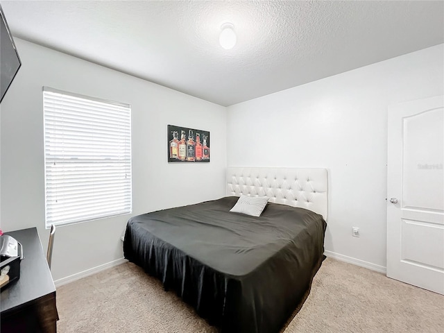 bedroom with light carpet and a textured ceiling