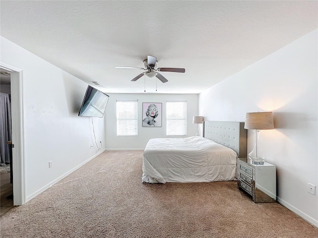 carpeted bedroom featuring ceiling fan and a textured ceiling