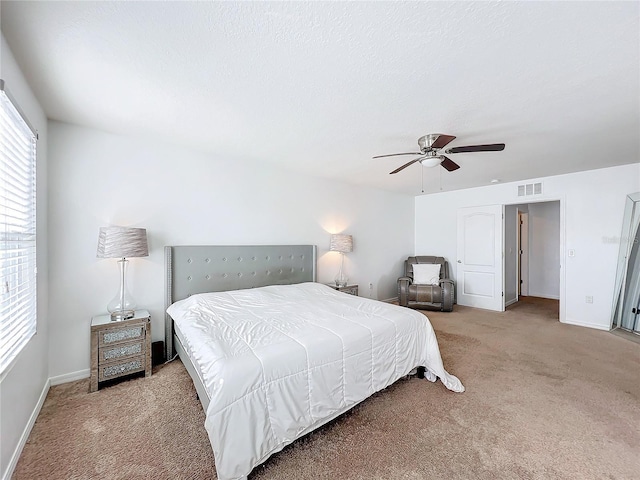 carpeted bedroom with ceiling fan and a textured ceiling