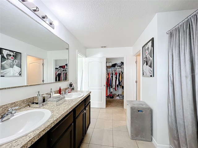 bathroom with vanity, tile patterned floors, and a textured ceiling