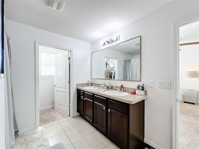 bathroom with vanity, tile patterned flooring, and a textured ceiling