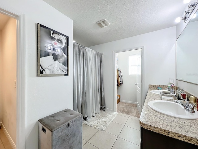 bathroom with vanity, tile patterned flooring, and a textured ceiling