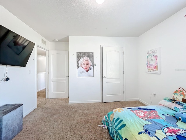 bedroom featuring light colored carpet and a textured ceiling