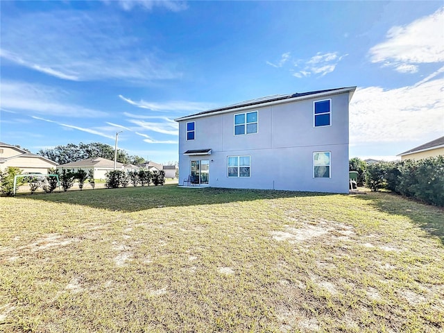 rear view of property featuring a lawn