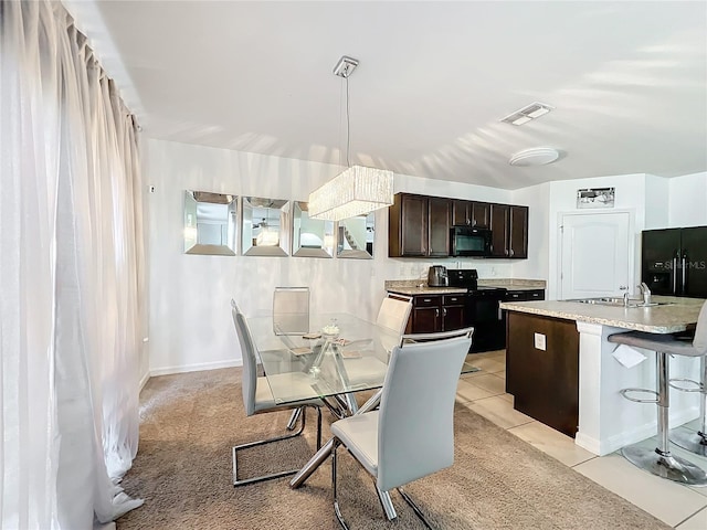 dining space featuring sink and light tile patterned flooring