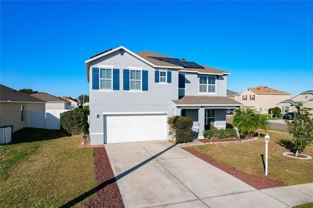 front facade featuring a garage, a front yard, and solar panels