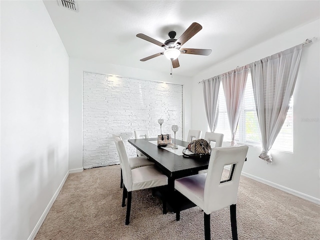 dining space featuring light carpet and ceiling fan