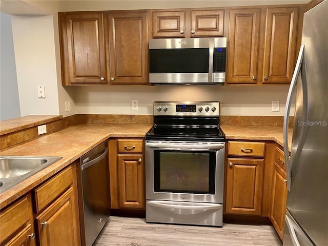 kitchen featuring light hardwood / wood-style floors, sink, and appliances with stainless steel finishes