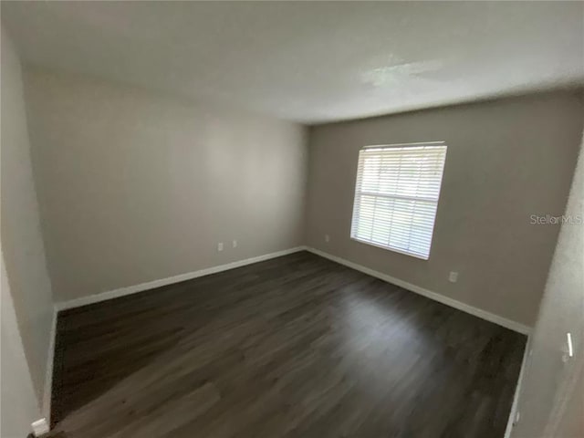 unfurnished room with dark hardwood / wood-style flooring