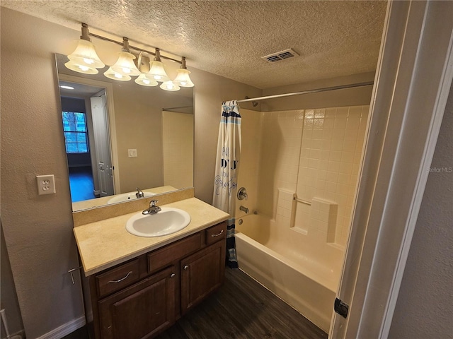 bathroom featuring hardwood / wood-style flooring, a textured ceiling, vanity, and shower / bathtub combination with curtain