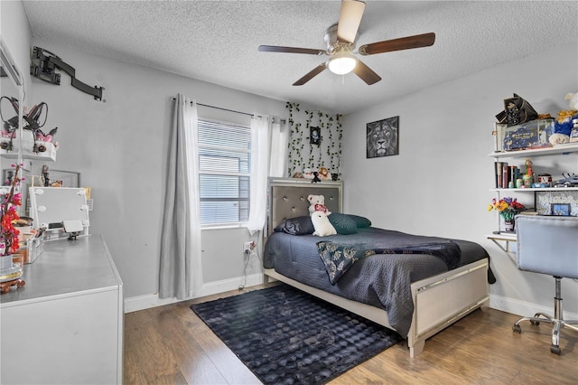 bedroom featuring ceiling fan, dark hardwood / wood-style floors, and a textured ceiling