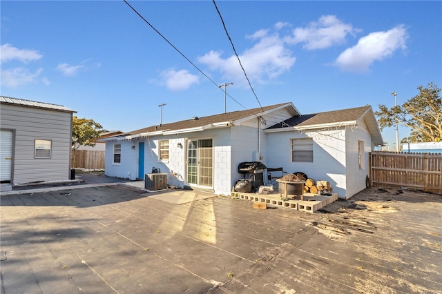 rear view of property featuring central AC unit and a patio