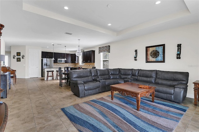 tiled living room featuring a tray ceiling