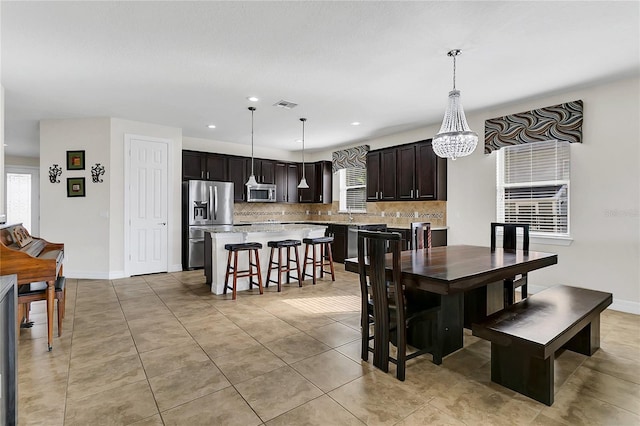 dining area with light tile patterned floors, sink, and a chandelier