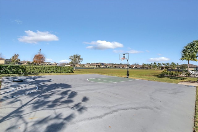 view of sport court with a lawn