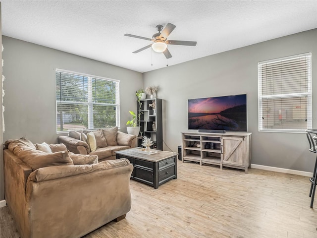 living room featuring a textured ceiling, hardwood / wood-style flooring, and ceiling fan