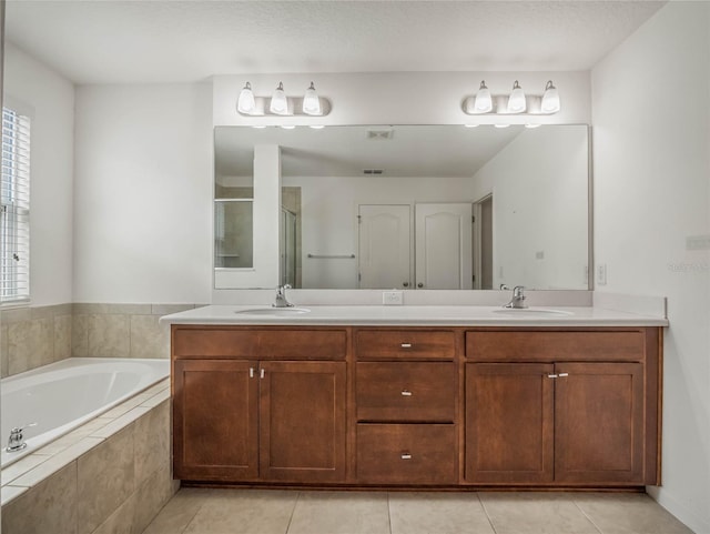 bathroom featuring tile patterned floors, vanity, and shower with separate bathtub