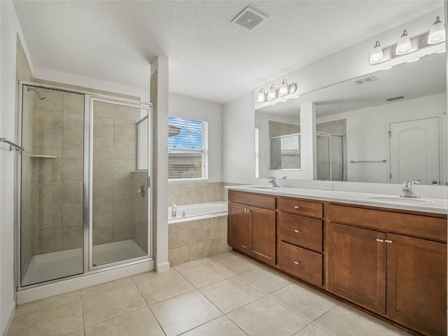 bathroom with a textured ceiling, vanity, tile patterned floors, and independent shower and bath