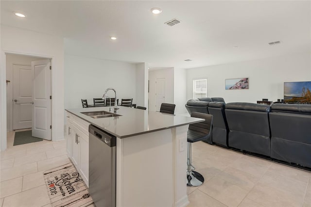 kitchen with dishwasher, a breakfast bar, a kitchen island with sink, white cabinets, and sink