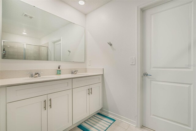 bathroom featuring tile patterned flooring, vanity, and a shower with shower door