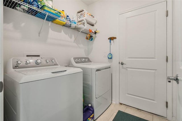 laundry room featuring washing machine and clothes dryer and light tile patterned flooring