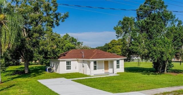 view of front of home featuring central AC unit, covered porch, and a front yard