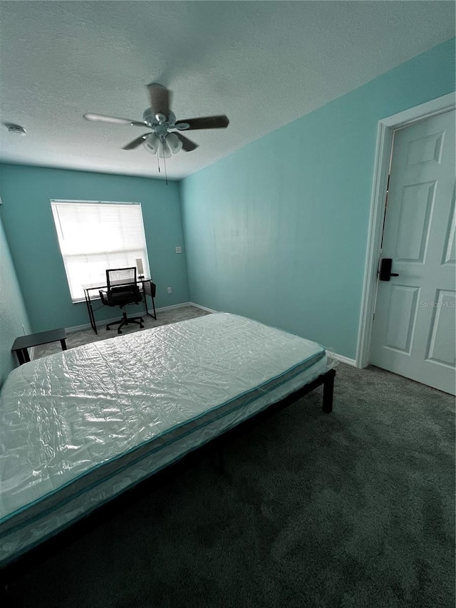 bedroom featuring a textured ceiling, carpet floors, and ceiling fan