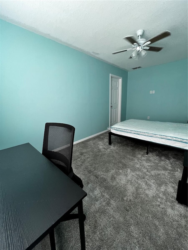 bedroom featuring dark colored carpet, ceiling fan, and a textured ceiling