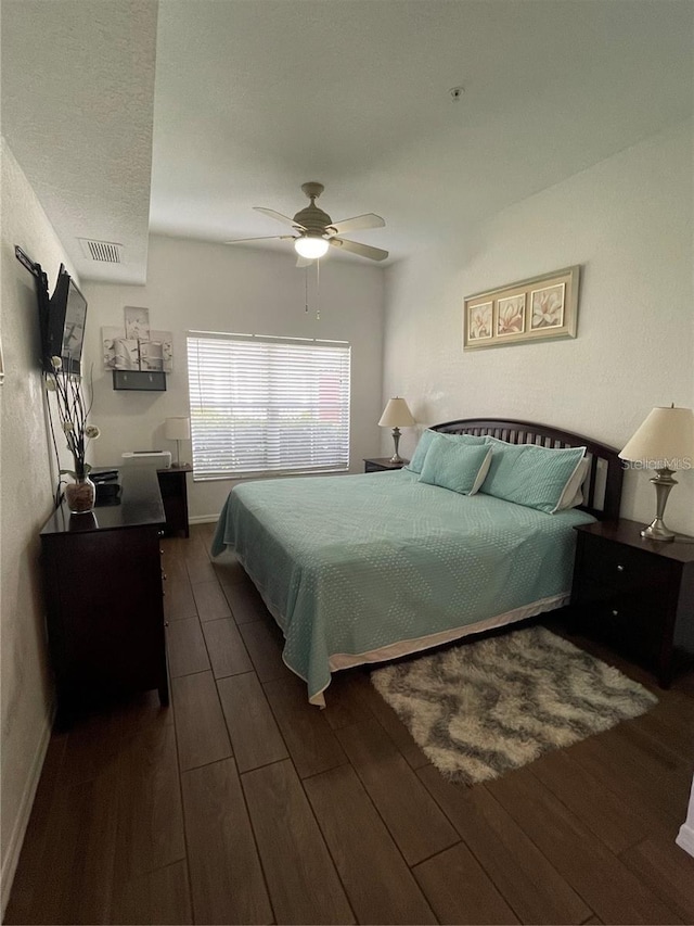 bedroom with ceiling fan and dark wood-type flooring