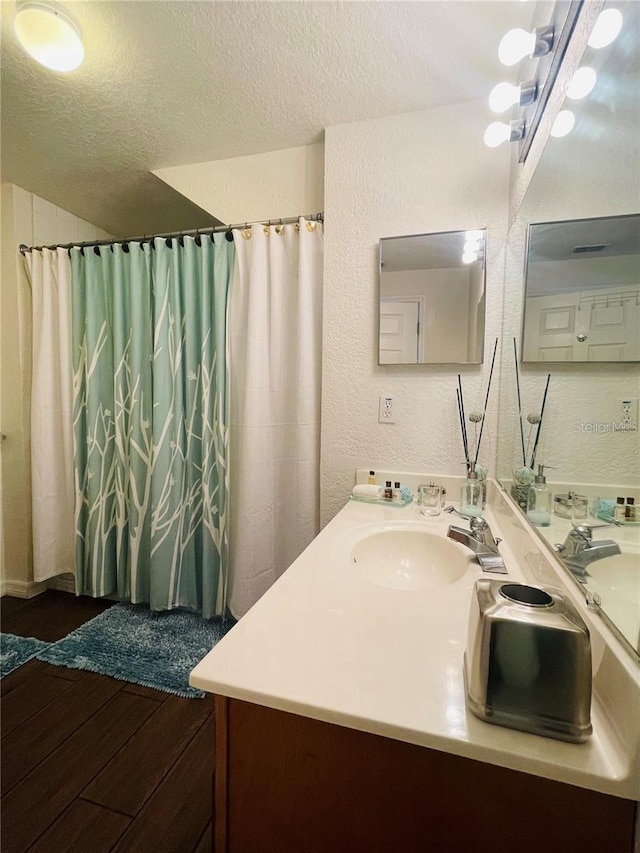 bathroom featuring vanity, wood-type flooring, and a textured ceiling