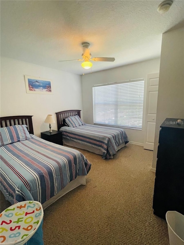 bedroom featuring carpet flooring, ceiling fan, and a textured ceiling