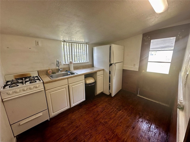 kitchen with dark hardwood / wood-style flooring, white appliances, a textured ceiling, and sink