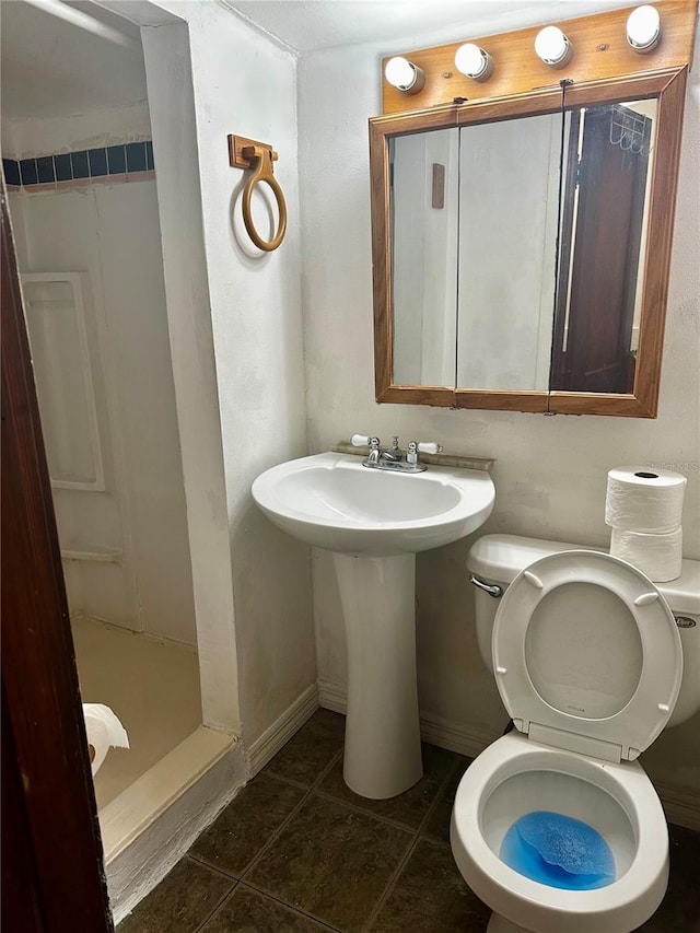 bathroom featuring tile patterned floors, toilet, and a shower