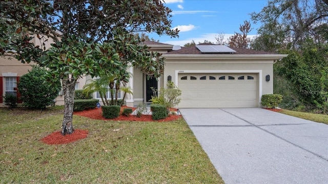 view of front of house featuring a garage, a front lawn, and solar panels