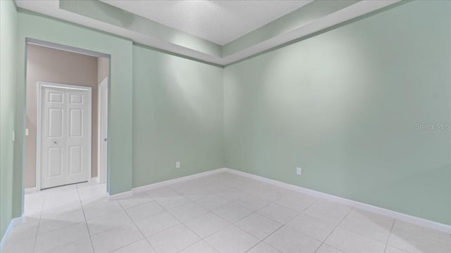 tiled spare room featuring a textured ceiling